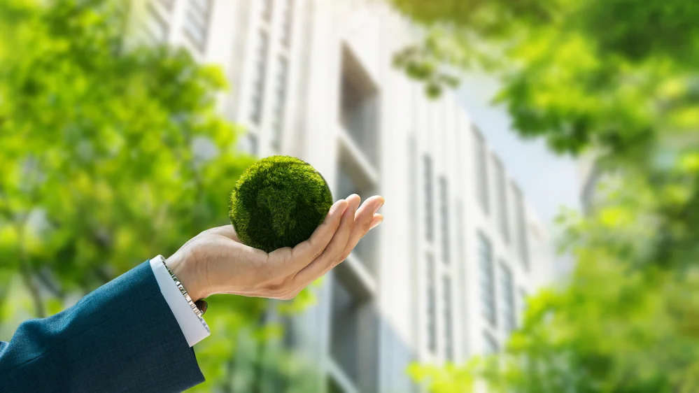 certificação esg Mão segurando o Globo Terrestre feito com grama. Uma representação da abordagem de certificação ESG