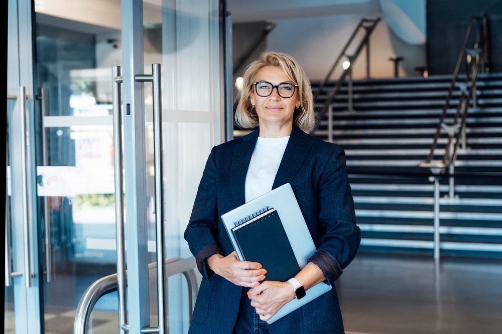 Mulher em ambiente corporativo representando liderança e alta direção.