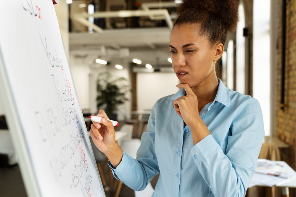 Mulher analisando informa&ccedil;&otilde;es e planejando a&ccedil;&otilde;es em um ambiente de trabalho voltado ao desenvolvimento de compet&ecirc;ncias.